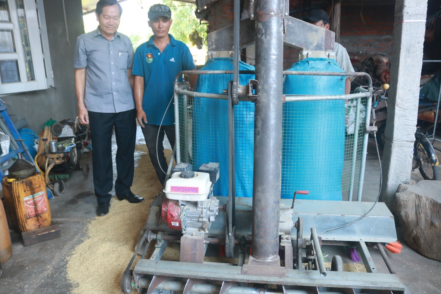 Ông Nguyễn Văn Khoa,Chủ tịch Liên hiệp Hội Phú Yên (bên trái) đang khảo sát thực tế máy hốt lúa của anh Nguyễn Ngọc Trí